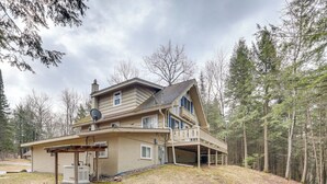 A two-story house with a covered patio and a satellite dish. - Boat, Paddle, UTV & More: Getaway in Saint Germain (St Germain)