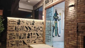 A building facade with hieroglyphics and a large mural of a pharaoh. - red pyramids hotel (Giza Governorate)