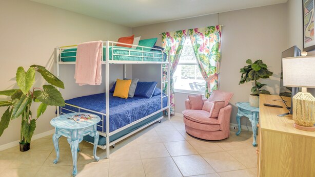 A bunk bed with pillows, a chair, a small table, and a lamp. - Private Pool & Park Access: Cozy South Daytona Gem (Daytona Beach)