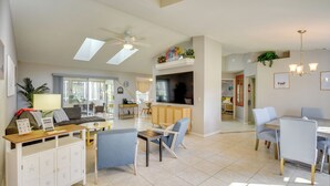 A spacious living area with a sofa, chairs, a dining table, and a kitchen in the background. - Private Pool & Park Access: Cozy South Daytona Gem (Daytona Beach)