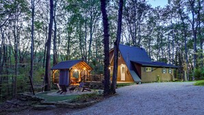 A cabin with a large deck and a covered outdoor seating area, surrounded by a forest. - Hocking Hills 'social Distance Cabin' w/ Hot Tub (Laurelville)