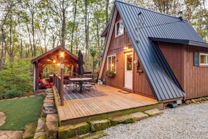 A wooden cabin with a deck, a small porch, and a dining area with outdoor furniture. - Hocking Hills 'social Distance Cabin' w/ Hot Tub (Laurelville)