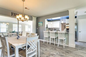 A spacious dining area with a chandelier, white furniture, and a kitchen in the background. - 4 Mi to Venice Beach: Home w/ Patio & Yard (Venice)