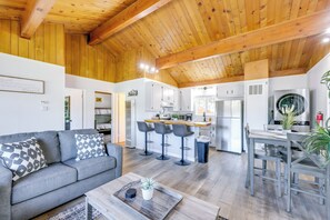 A spacious living area with a grey sofa, a coffee table, and a kitchen in the background. - Close to Skiing & Lake: Big Bear Mountain Getaway (Big Bear City)