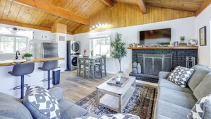 A modern kitchen with a bar area, a fireplace, and a seating area with a sofa and chairs. - Close to Skiing & Lake: Big Bear Mountain Getaway (Big Bear City)