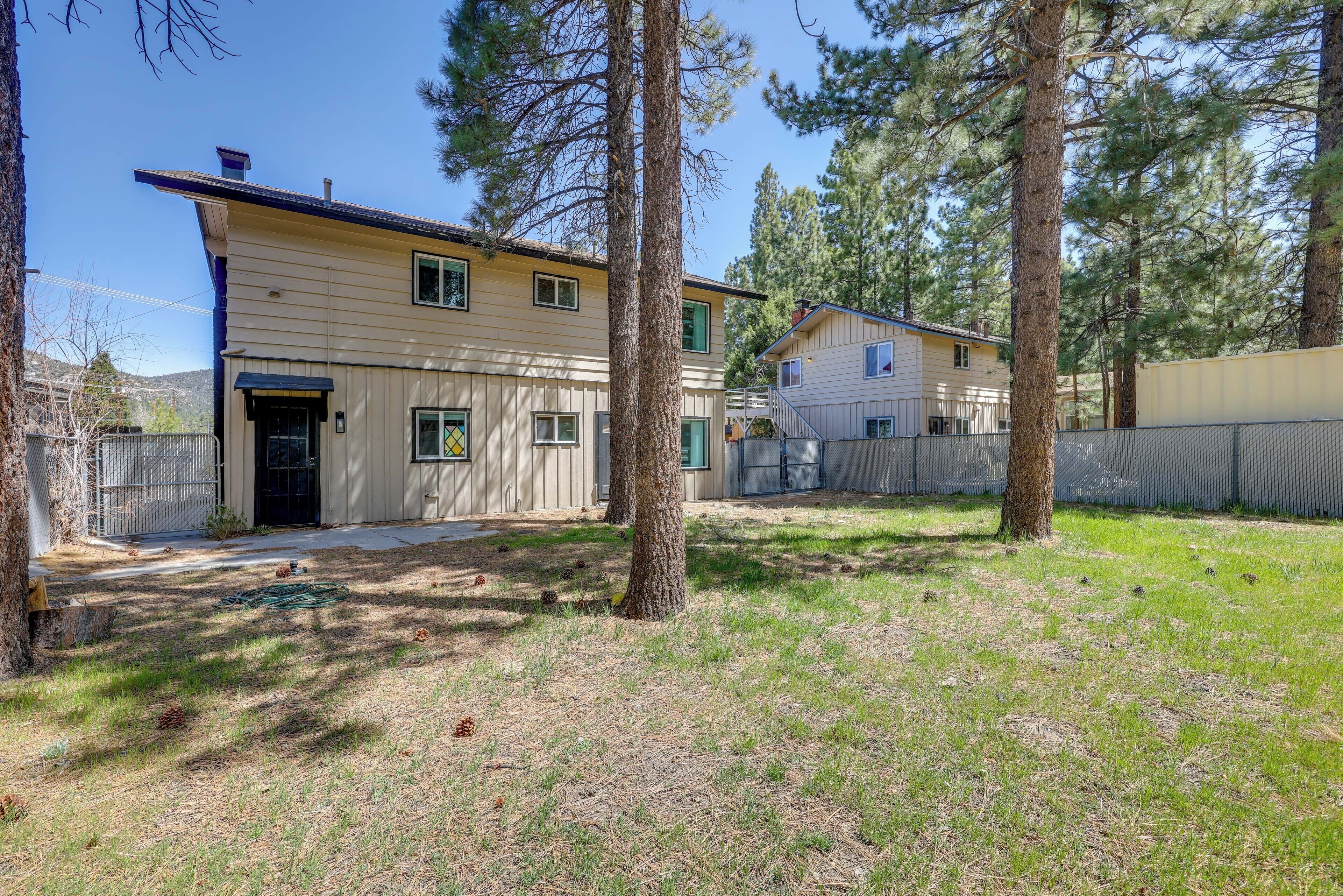 A two-story house with a covered patio and a fenced yard.