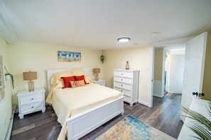 A bedroom with a bed, nightstands, a dresser, and a painting on the wall. - Family-Friendly 4Br Near Beach, Smart Tv Fun (Wildwood)