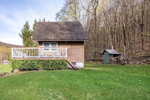 Relax on the sheltered porch, surrounded by a well-maintained lawn and dense trees.