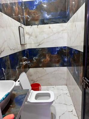Un baño con inodoro, lavamanos y ducha.