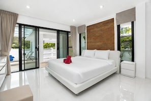 Una moderna camera d'hotel con un ampio letto, una porta vetrata che dà su un balcone e un pannello decorativo in legno.