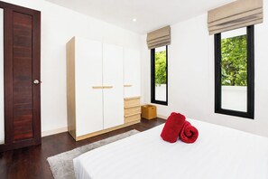 A bedroom with a bed, a wardrobe, a window with a view, and a door. - Designer 3BR Villa Silver Pool in Kamala (Kamala)