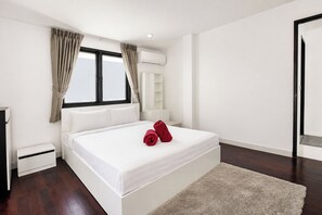 Una camera da letto moderna con un letto grande, biancheria da letto bianca, un comodino e una finestra con tende.