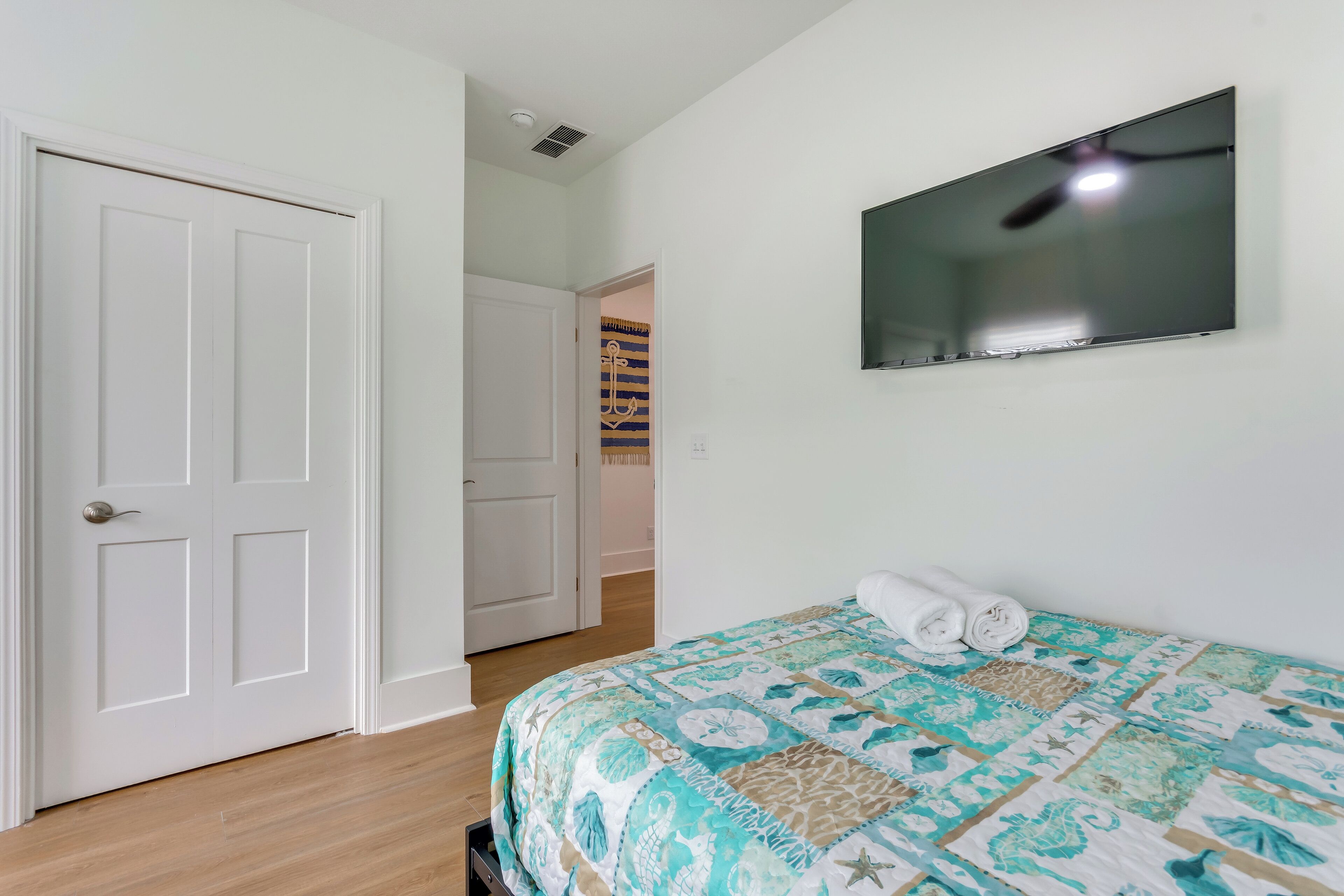 A bedroom with a bed, a TV, and a door.