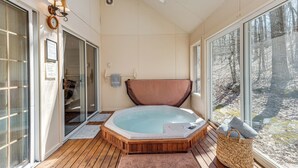 A hot tub in a room with large windows, a wooden floor, and a view of trees outside. - Access to Jack Frost Ski Resort: Home w/ Hot Tub (White Haven)