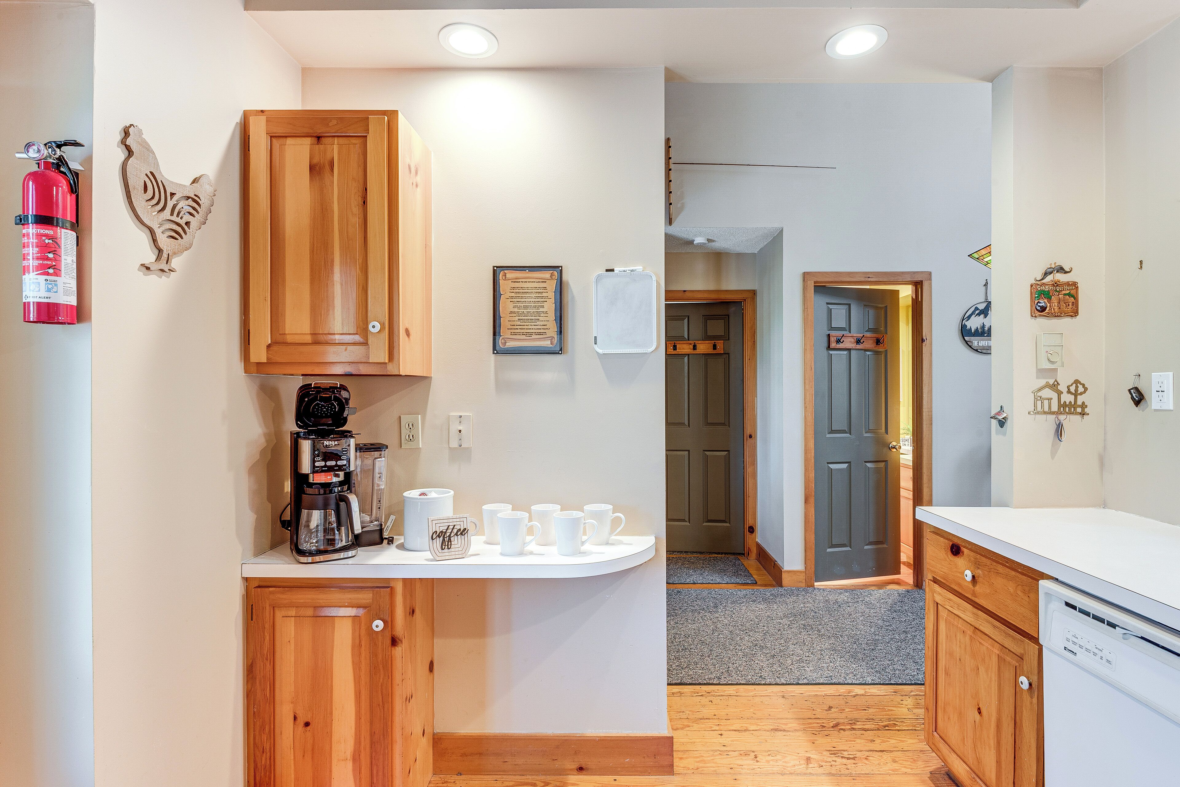 A kitchen with wooden cabinets, a coffee maker, and a white countertop.