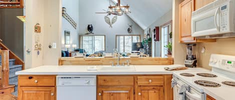 A modern kitchen with wooden cabinets, a built-in dishwasher, a microwave, and a stove.