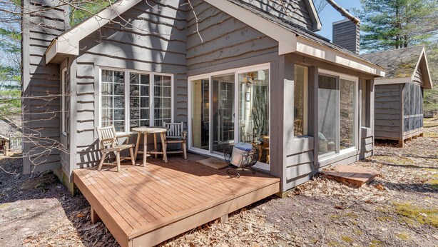 A cabin with a deck, large windows, and a chimney. - Access to Jack Frost Ski Resort: Home w/ Hot Tub (White Haven)