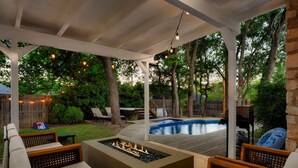A covered outdoor patio with a fire pit, seating, and a pool. - Upscale Retreat: Pool, Hot Tub, Gym & Games (Round Rock)