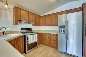 Una cocina con armarios de madera, electrodomésticos de acero inoxidable y un horno empotrado.