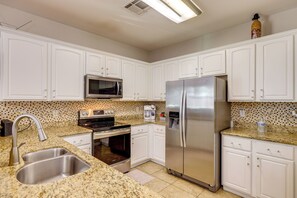 A modern kitchen with white cabinets, stainless steel appliances, granite countertops, and a microwave. - 2 Mi to Desert Diamond Arena: Home w/ Patio! (Phoenix)