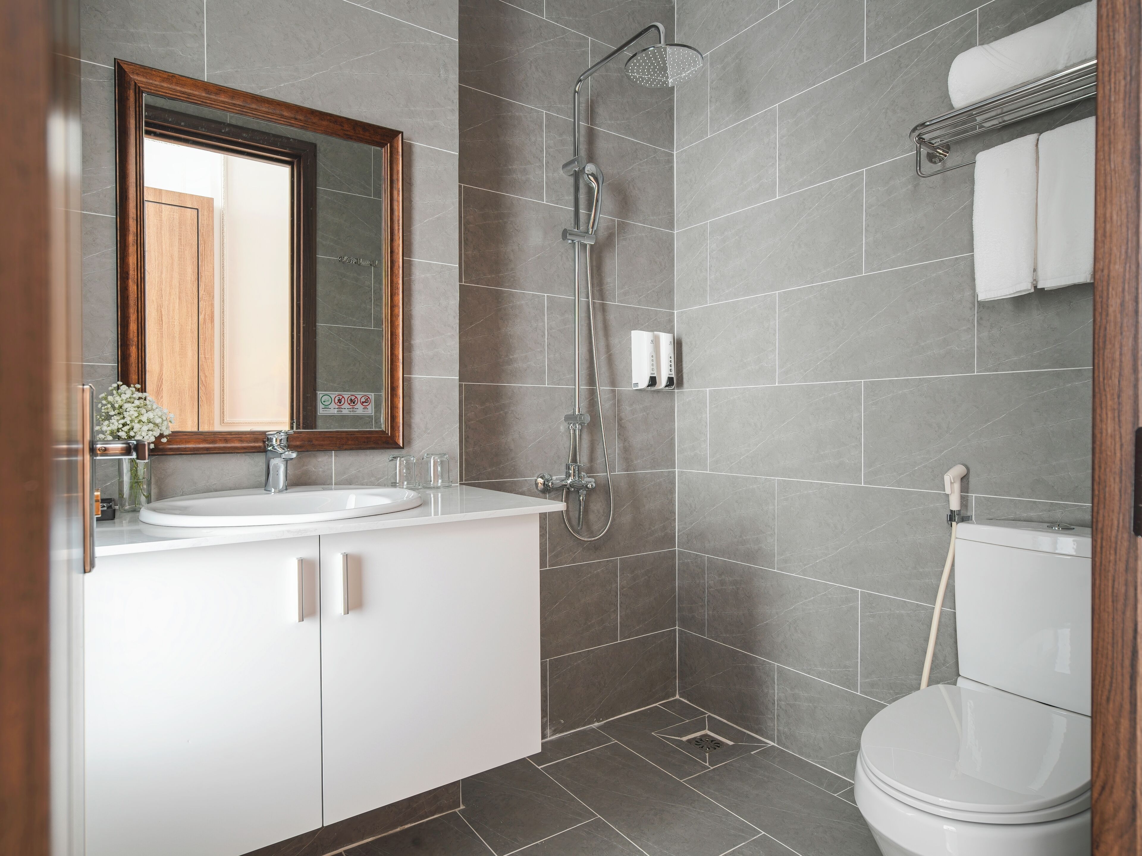 A modern bathroom with a shower, toilet, and sink.