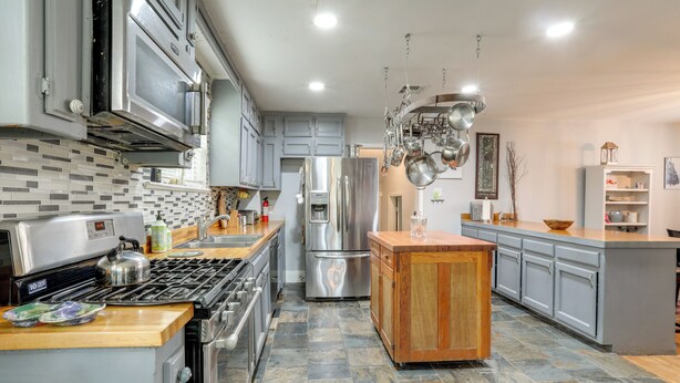 Una cocina moderna con electrodomésticos de acero inoxidable, una isla central y salpicadero de azulejos.