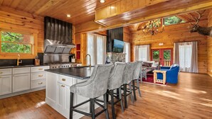 Ein Holzblockhaus-Innenraum mit Küche, Essbereich und Wohnzimmer.