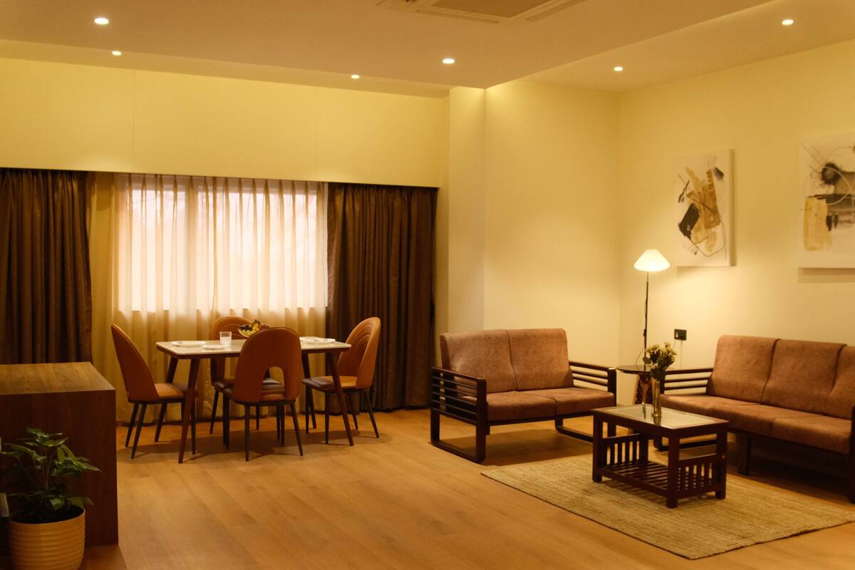 A living room with a sofa, armchairs, a coffee table, and a dining area with a table and chairs.