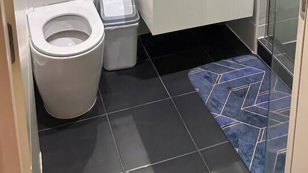 A modern bathroom with a toilet, sink, and shower.