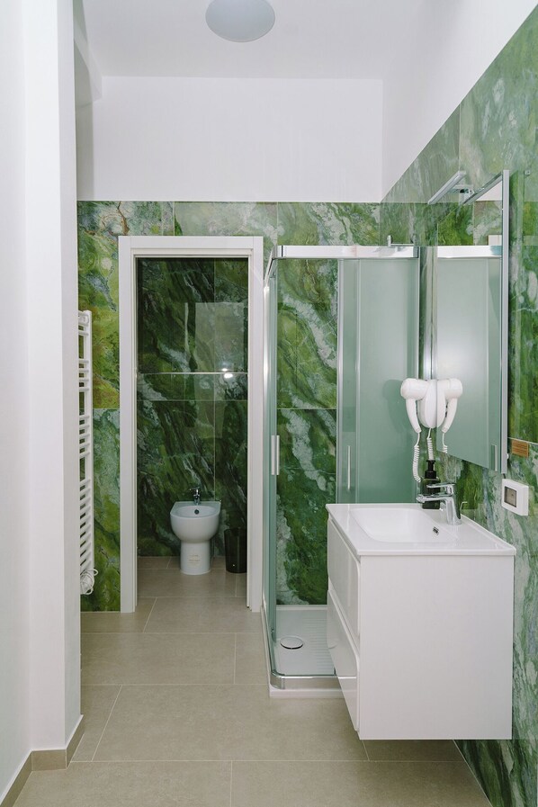A bathroom with a shower, sink, and toilet. - Opera House Florence (Florence)