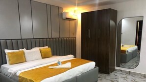 Une chambre moderne avec un grand lit, une armoire, un miroir et un sol en marbre.