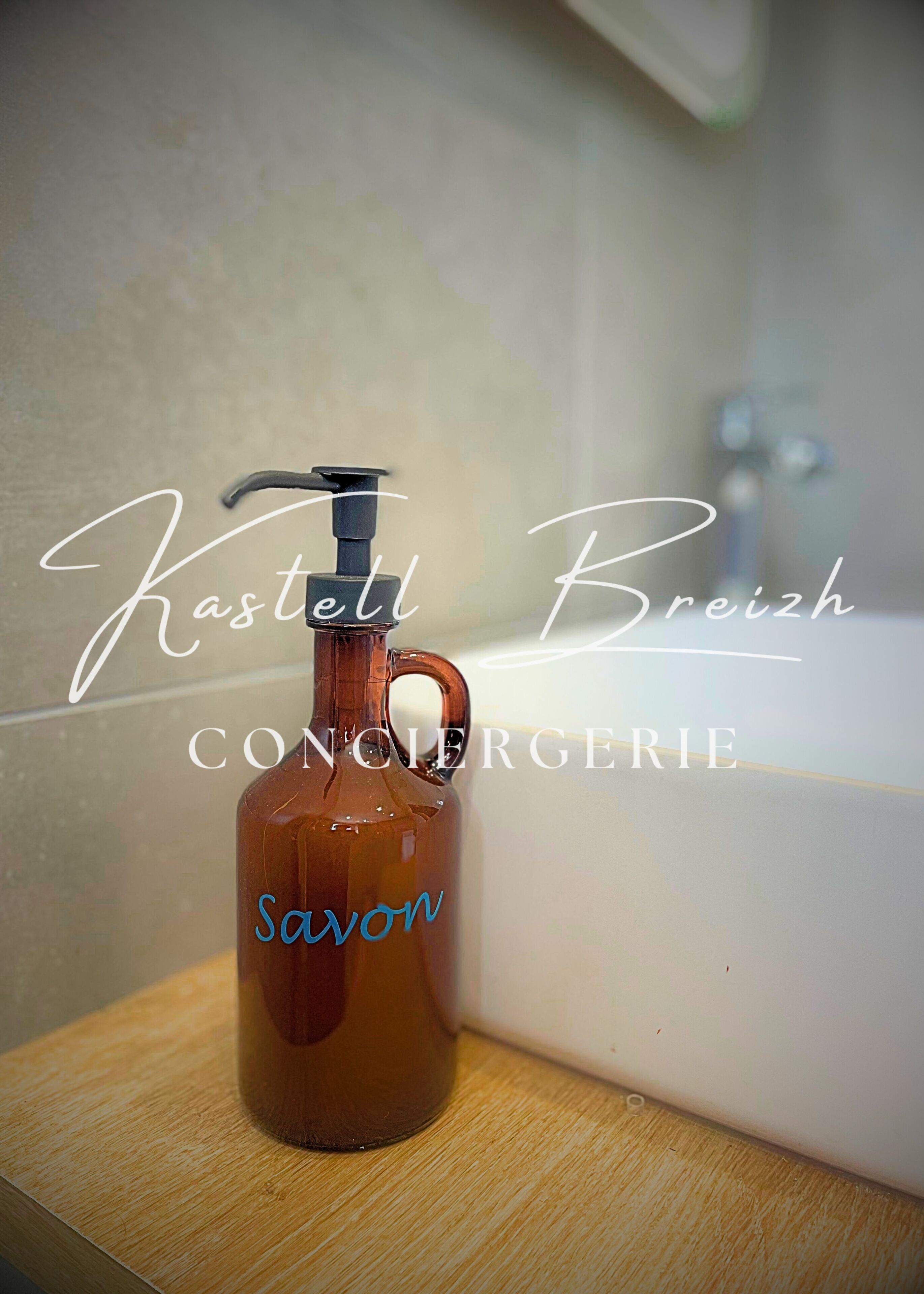 Ein brauner Seifenspender mit dem Aufdruck "Savon" auf einer Holzoberfläche neben einer Badewanne.