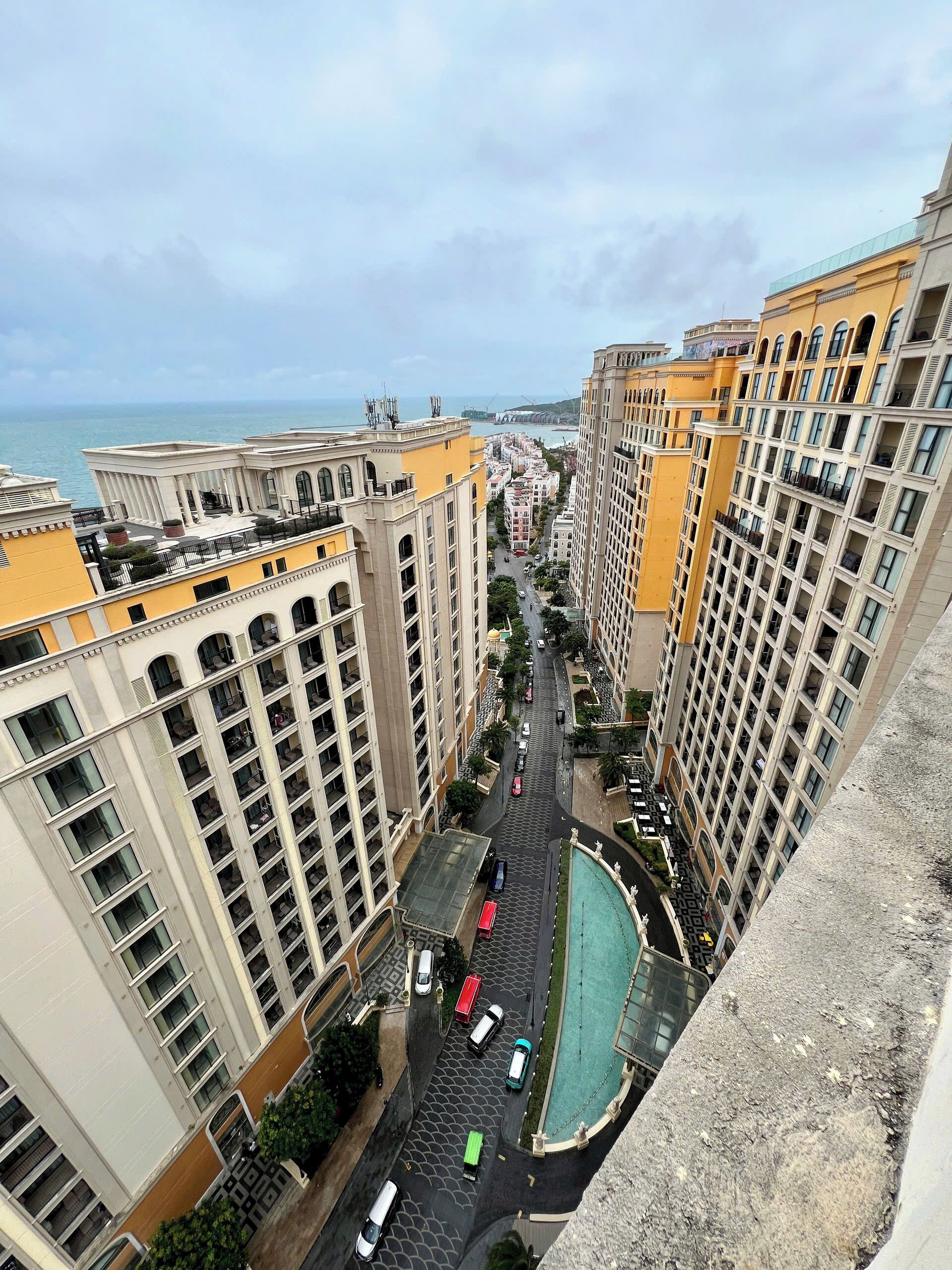 Un edificio de gran altura con múltiples balcones y vista al mar.