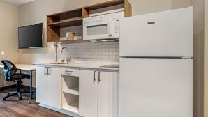 A modern kitchen with white cabinets, a built-in microwave, and a refrigerator. - Extended Stay America Premier Suites - Yuma (Yuma)