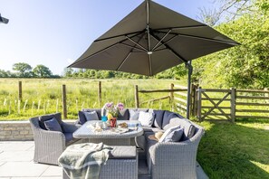 Relax in the shaded outdoor seating area with a semi-circular sofa and round table.