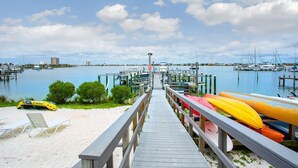 A wooden pier leading to a marina with boats docked.