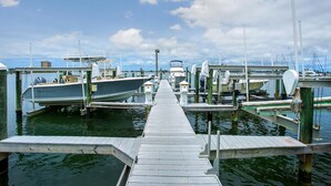 A marina with multiple boats docked at wooden piers.
