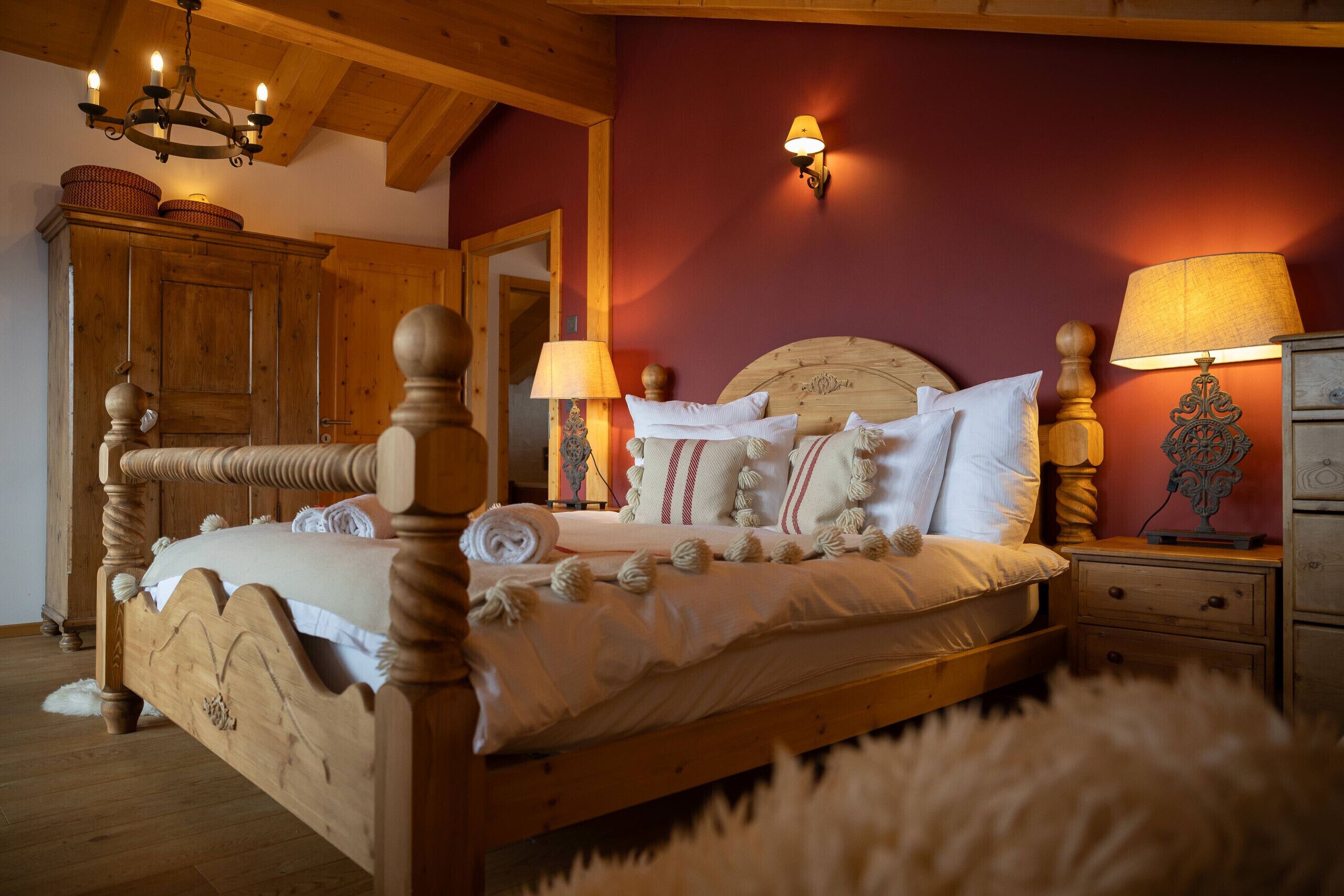 Un lit en bois avec une tête de lit, deux lampes de chevet et une table de chevet avec une lampe.