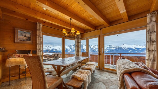 A wooden interior with a wooden table, benches, and a sofa. - Chalet Chafrebelle - sauna & view (Haute-Nendaz)