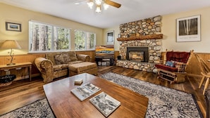 A cozy living room with a fireplace, comfortable seating, and a television. - 838 Placer Avenue 4 Bedroom Home (South Lake Tahoe)