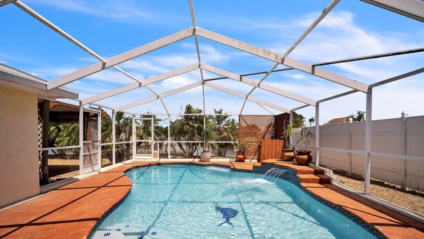 Una piscina coperta con un elemento d'acqua cristallina e una struttura del tetto dalla forma geometrica.