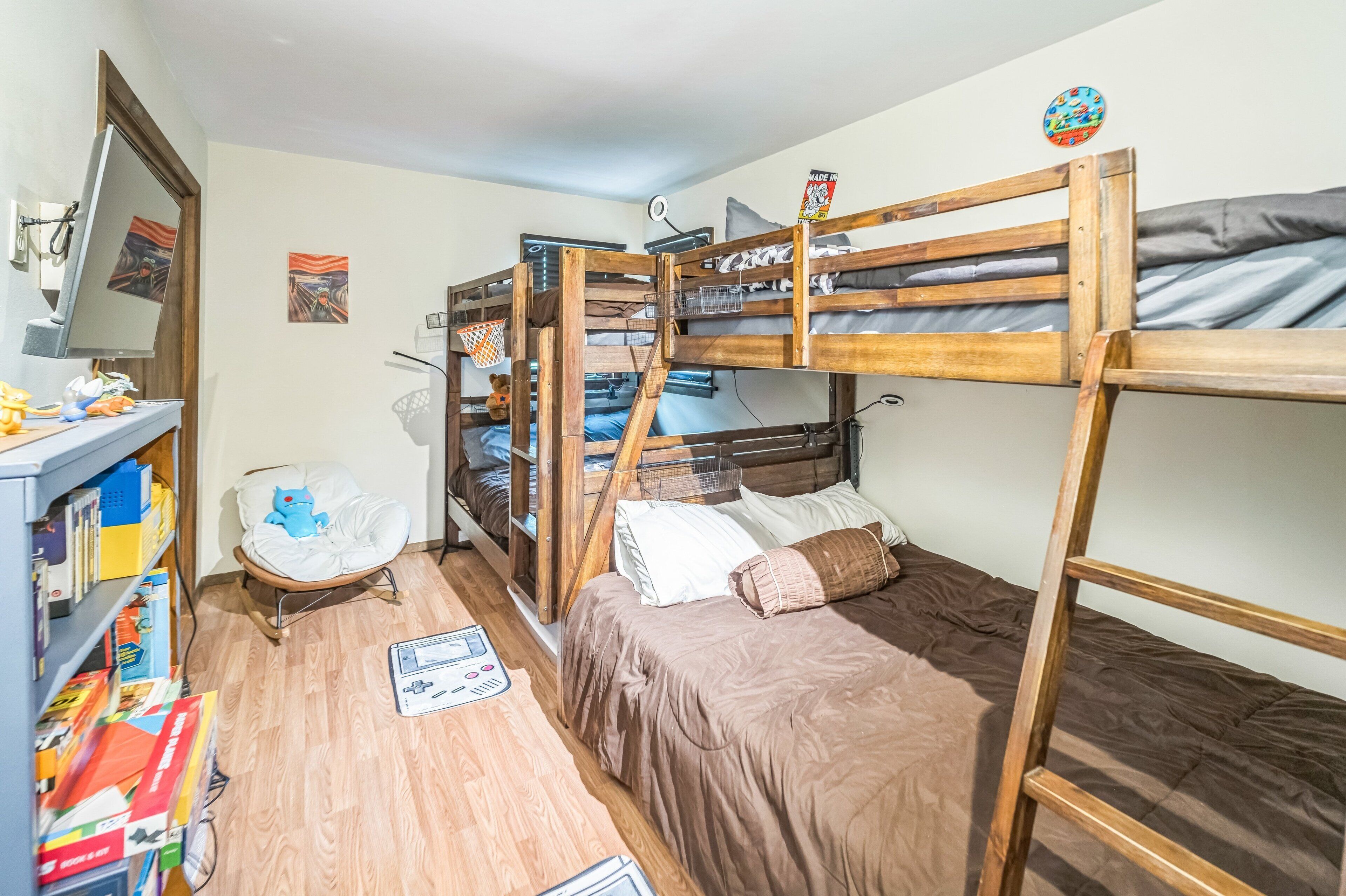 Dormitorio con literas, escritorio, silla y estanterías.