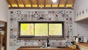A kitchen with a wooden ceiling, a tiled backsplash, a window with blinds, and a wooden countertop. - Omah Ndoro Sugih (Triwidadi)