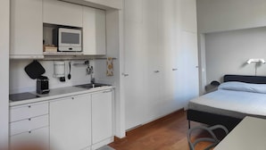 A compact bedroom with a bed, a small kitchenette, and a wardrobe. - Citrus Pop Holiday home in Piazza del Popolo (Roma)