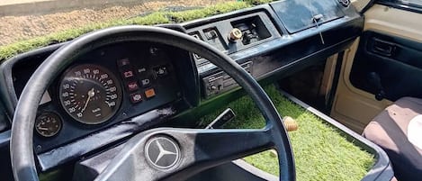 Das Interieur eines Fahrzeugs mit Lenkrad, Armaturenbrett und Schalthebel.