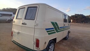 A white van parked in a sandy area with a green and blue stripe design. - Vintage Camper Van in Mallorca, with everything for live, 9 persons driving. (Sol de Mallorca)