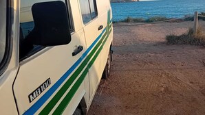 A white van with green stripes parked on a dirt path near a body of water. - Vintage Camper Van in Mallorca, with everything for live, 9 persons driving. (Sol de Mallorca)