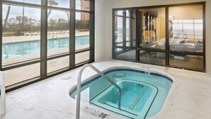 An indoor swimming pool with clear views of the outside, a tiled floor, and a pool ladder. - Grand Pointe 310, panoramic views, huge balcony, 3rd floor with 3 bedrooms, 3.5 baths (Orange Beach)