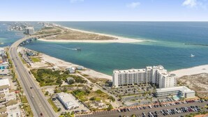 A coastal hotel with a parking lot, a beach, and a bridge in the background. - Grand Pointe 310, panoramic views, huge balcony, 3rd floor with 3 bedrooms, 3.5 baths (Orange Beach)