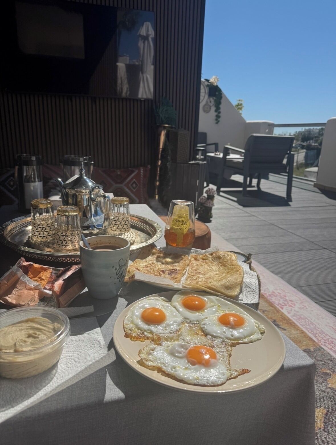 Un petit-déjeuner composé d’œufs, de pain grillé et de café, servi sur une terrasse avec vue.